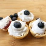 strawberry mini pies with blueberries and whipped topping